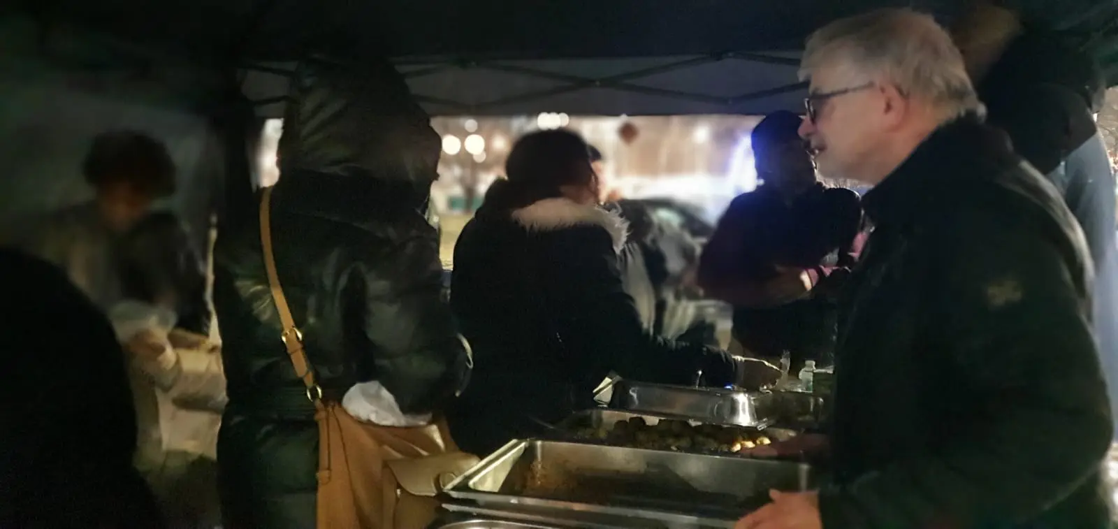 A volunteer helping serve the evening meal